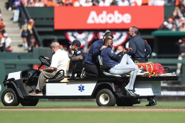 Seattle Mariners right fielder Victor Robles, front right, is carted off the field during the ninth inning of a baseball game against the San Francisco Giants in San Francisco, Sunday, April 6, 2025. (AP Photo/Kavin Mistry)