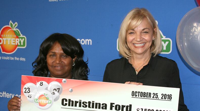 Christina Ford, 64 of Dallas, poses with her $7.5 million lottery check. She split a July jackpot with a winner in Virginia.