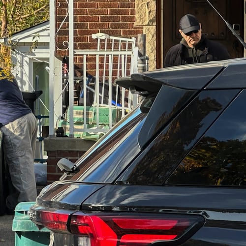 FBI agents gather outside a home in a Dearborn, Mich., neighborhood on Friday, Oct. 31, 2025. (AP Photo/Mike Householder)