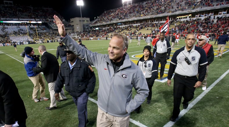 Georgia coach Mark Richt greets fans as he leaves the field after Georgia defeated Georgia Tech 41-34 in double overtime on Saturday, November 30, 2013, at Bobby Dodd Stadium in Atlanta.