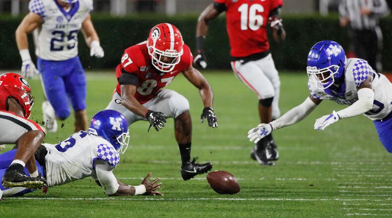 Kentucky wide receiver Josh Ali (6) fumbles a punt return while Bulldogs wide receiver Tyler Simmons (87) and Wildcats defensive back Brandin Echols (26) try to recover it amid the rain Saturday, Oct. 19, 2019, at Sanford Stadium in Athens.
