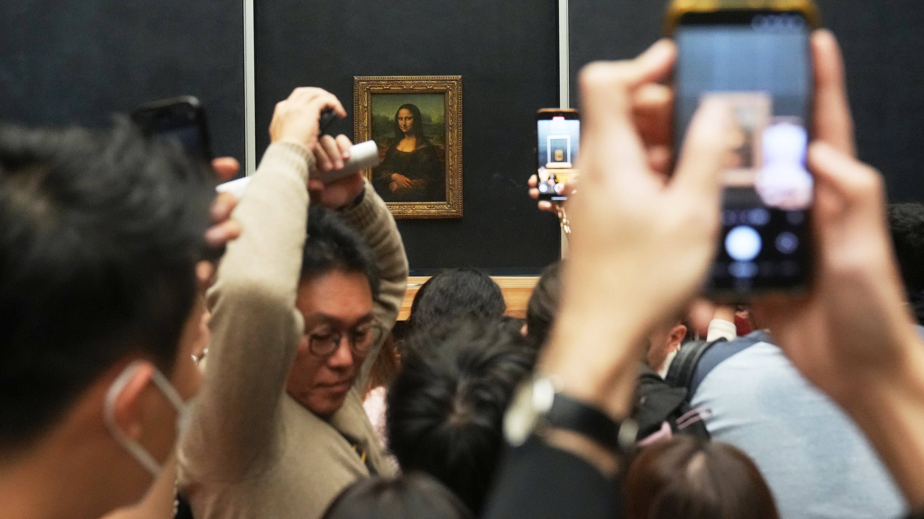 Visitors watch Leonardo da Vinci's painting Mona Lisa in Louvre museum three days after historic jewels were stolen in a daring daylight heist, Wednesday, Oct. 22, 2025 in Paris. (AP Photo/Thibault Camus)