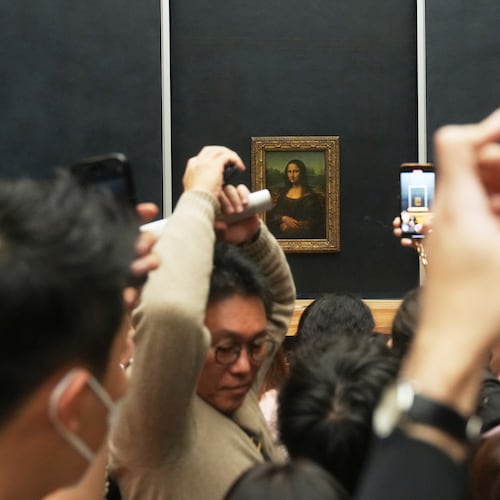 Visitors watch Leonardo da Vinci's painting Mona Lisa in Louvre museum three days after historic jewels were stolen in a daring daylight heist, Wednesday, Oct. 22, 2025 in Paris. (AP Photo/Thibault Camus)