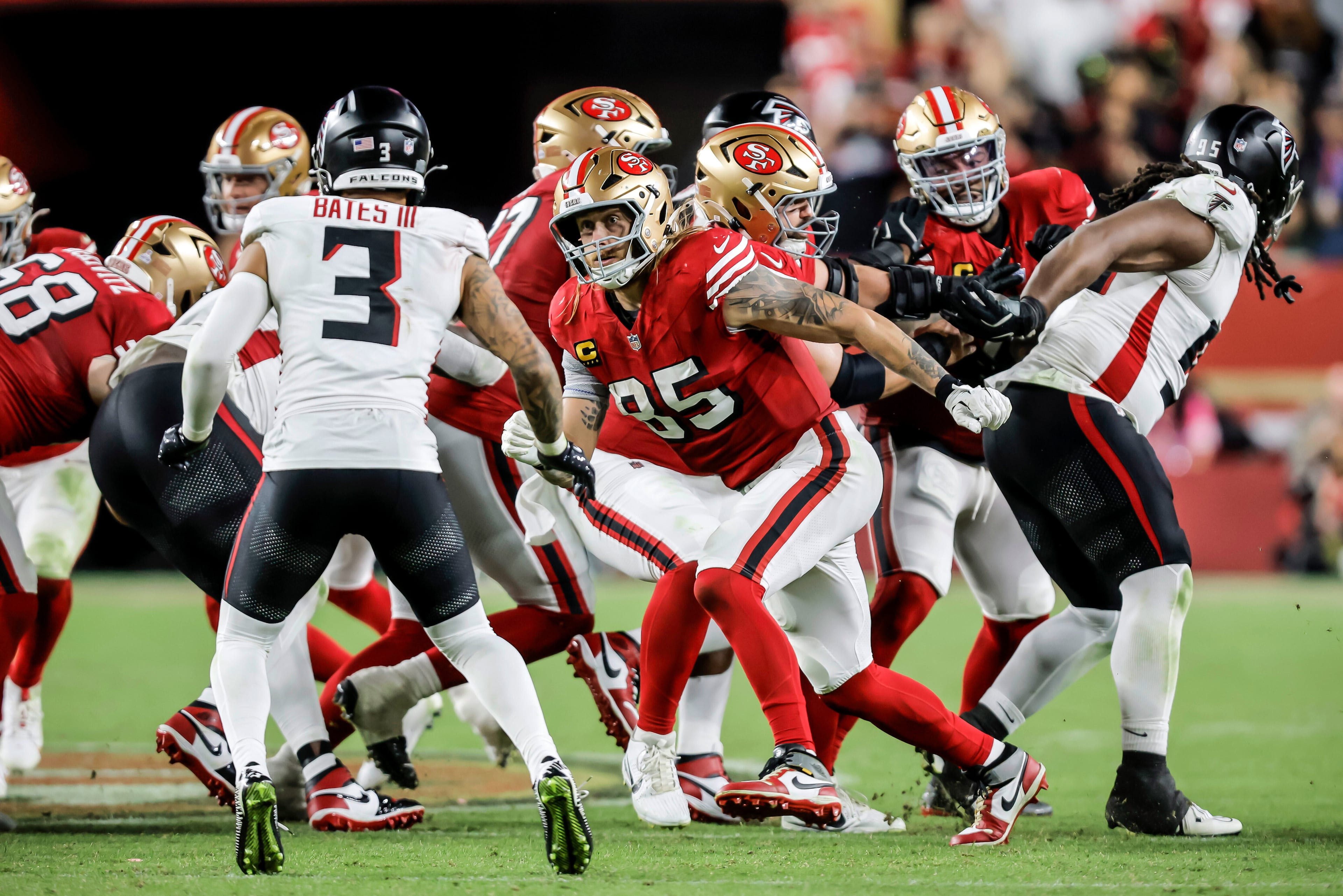 San Francisco 49ers tight end George Kittle (center) blocks for teammate Christian McCaffrey against the Atlanta Falcons on Sunday, Oct. 19, 2025, in Santa Clara, Calif. (Carlos Avila Gonzalez/San Francisco Chronicle via AP)