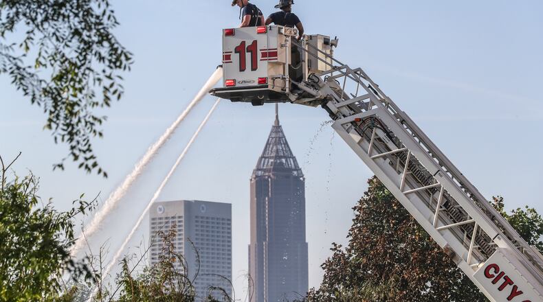 Atlanta firefighters put out a fire on May 21, 2021. Firefighters were among the city employees who got additional pay for working on the front lines during the pandemic.