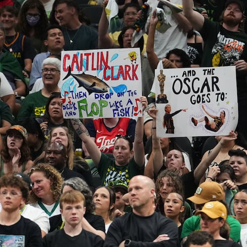 Fans wave signs referencing Indiana Fever guard Caitlin Clark during the second half of a WNBA basketball game between the Seattle Storm and the Indiana Fever, Tuesday, July 28, 2026, in Seattle. (AP Photo/Lindsey Wasson)