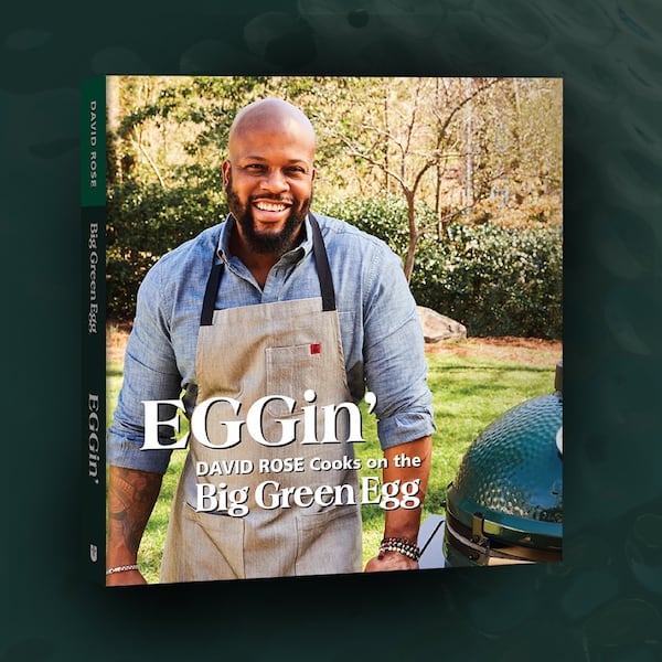The cover of the cookbook, EGGin’. has chef David Rose standing by a kamado-style cooker.