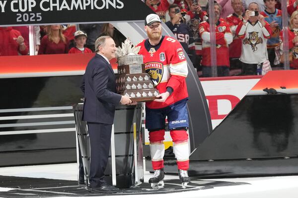 NHL commissioner Gary Bettman presents the Conn Smythe Trophy to Sam Bennett after defeating the Edmonton Oilers in Game 6 of the NHL hockey Stanley Cup Final Tuesday, June 17, 2025, in Sunrise, Fla. (AP Photo/Lynne Sladky)