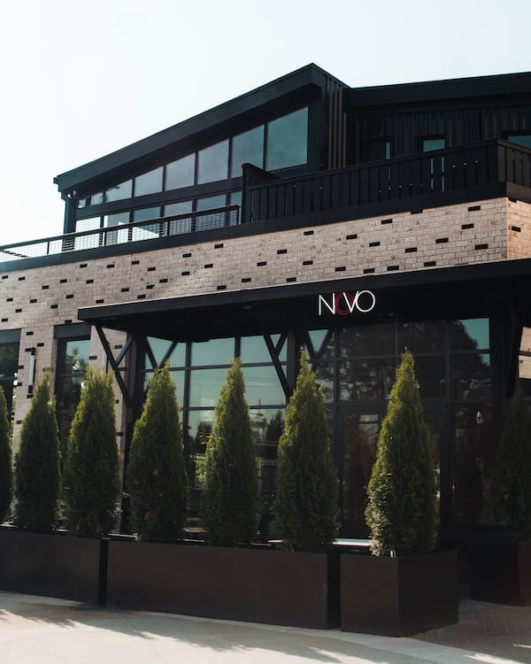 The exterior of a restaurant with a rooftop patio and a sign reading Novo Cucina