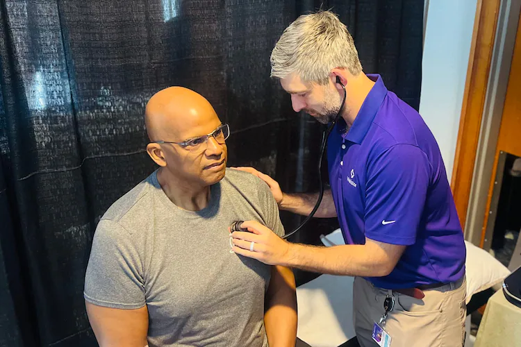 Dr. Connor O’Sullivan examines former Atlanta Falcons player and NFL retiree Philip McKinnely at an NFL health screening on Saturday, April 18, 2026, in Atlanta. (Courtesy of Wellstar Health System)