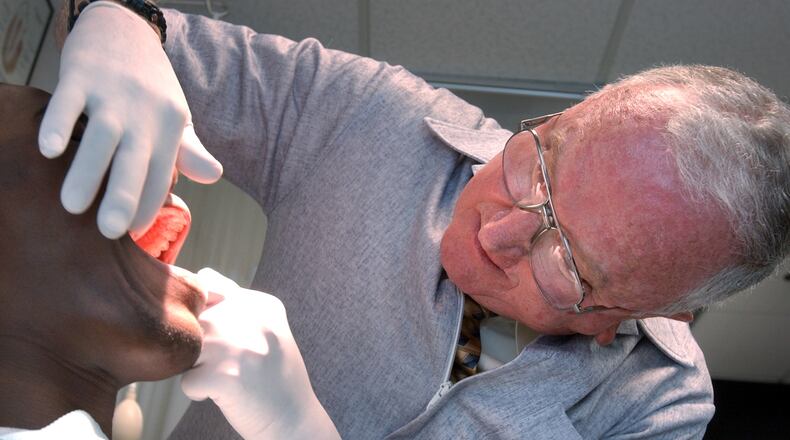 An August 2004 photo of Georgia Tech team doctor Aaron King taking a dental impression of then-freshman Calvin Johnson, one of thousands that King made for custom mouthguards over his nearly 60 years of service to the Yellow Jackets. (AJC file photo by Rich Addicks)