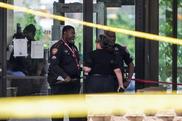 Law enforcement officers investigate the scene where a deputy and a suspect were shot near a courthouse complex in Houston, Monday, April 21, 2025. (Brett Coomer/Houston Chronicle via AP)