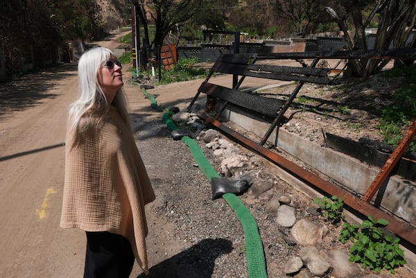 Kathryn Frazier looks at property, which was destroyed by the Eaton Fire in Altadena, Calif., on Tuesday, April 22, 2025. (AP Photo/Damian Dovarganes)