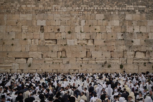 Covered in prayer shawls, Jewish men of the Cohanim Priestly caste participate in a blessing during the holiday of Passover, at the Western Wall, the holiest site where Jews can pray, in the Old City of Jerusalem, Tuesday, April 15, 2025. (AP Photo/Leo Correa)