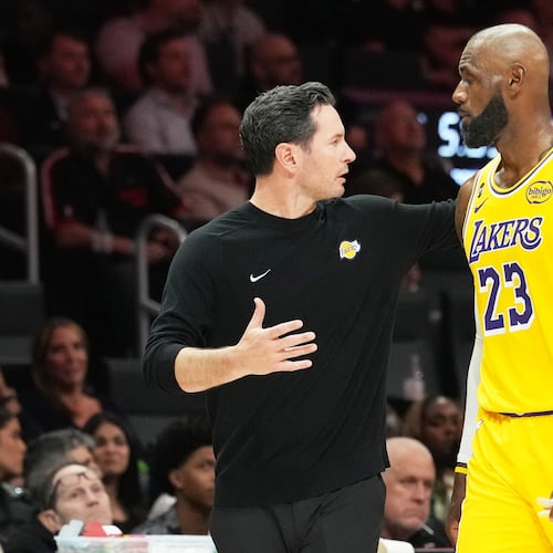 Los Angeles Lakers head coach JJ Redick, left, talks with forward LeBron James (23) during the second half of an NBA basketball game against the Miami Heat, Thursday, March 19, 2026, in Miami. (AP Photo/Lynne Sladky)