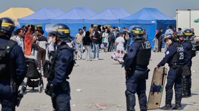 Police conduct a search operation at a makeshift camp of migrants who want to cross the English Channel to Britain near Dunkirk, northern France, Wednesday, May 27, 2026. (AP Photo/Jean-Francois Badias)