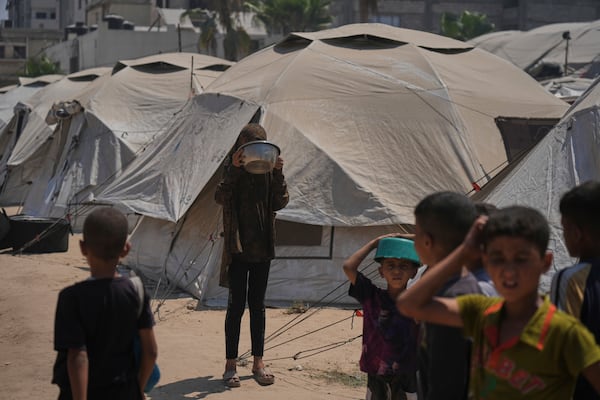 Displaced Palestinians wait for donated food at a community kitchen in Gaza City, northern Gaza Strip, Tuesday, July 22, 2025. (AP Photo/Jehad Alshrafi)