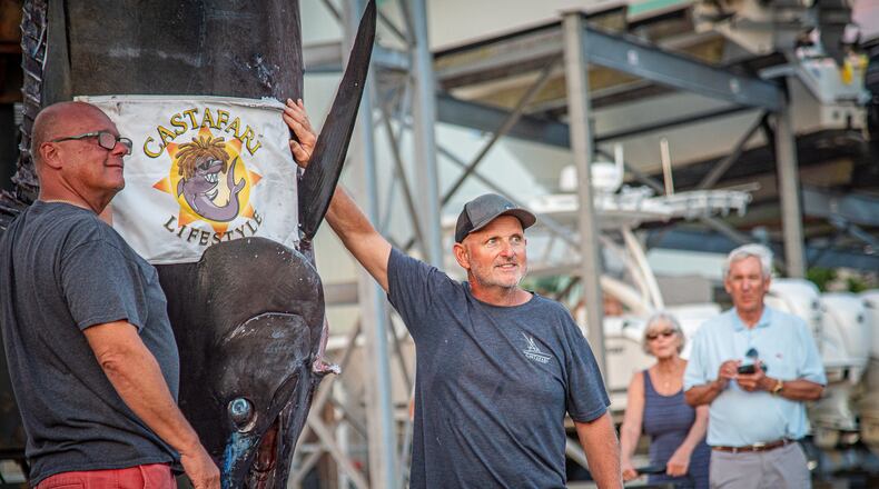 This photo provided by Jimmy Fee shows Walter Chapman, left, and Damon Sacco, captain of the Castafari, right, posing with an enormous blue marlin that they caught off the coast of Massachusetts, Wednesday, Aug. 19, 2026, in Falmouth, Mass. (Jimmy Fee via AP)