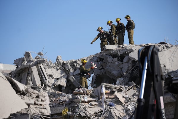 Israeli security forces inspect destroyed houses that were struck by a missile fired from Iran, in Rishon Lezion, Israel on Saturday, June 14, 2025. (AP Photo/Ohad Zwigenberg)