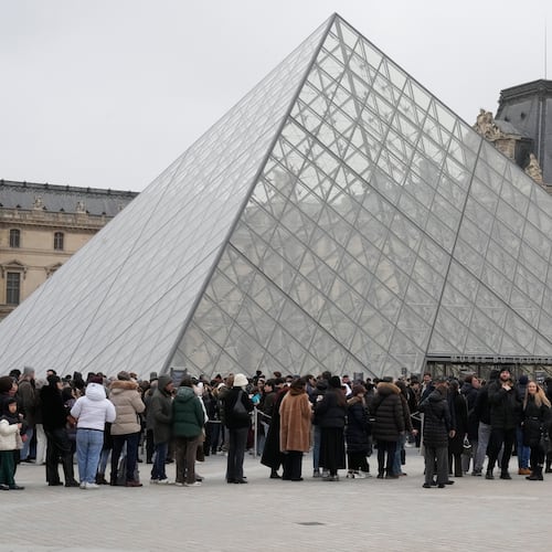 People queue outside the Louvre museum, in Paris, France, Friday, Feb. 13, 2026. (AP Photo/Michel Euler)