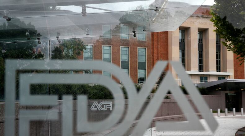 FILE - The U.S. Food and Drug Administration building is seen behind FDA logos at a bus stop on the agency's campus in Silver Spring, Md., Aug. 2, 2018. (AP Photo/Jacquelyn Martin, File)