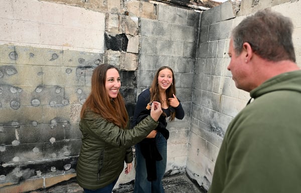 Rachel McNett, left, finds a piece of her old passport as daughter Teagan and husband Keith look on as they visit there house that burned in the Mountain Fire Wednesday, April 16, 2025, in Camarillo, Calif. (AP Photo/Wally Skalij)