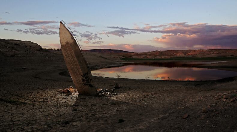 A boat that sank in Lake Mead resurfaces as water continues to recede in the nation's largest reservoir. The lake bed is littered with years of accumulated detritus that has been exposed as water levels have dropped to 30 percent of capacity and continue to fall after almost two decades of severe drought conditions in the American West. Lake Mead is fed by the Colorado River and millions of people rely on the reservoir for water supplies. (Luis Sinco/Los Angeles Times/TNS)