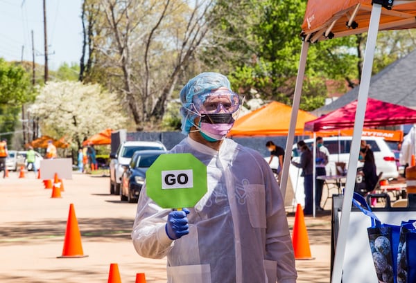 David Bentley, an engineer for Coca Cola, volunteers as crowd control with Ethne Health in Clarkston on Friday, April 3, 2020. The community health provider, inpartnership with the City of Clarkston, community churches and food banks provides free corona virus testing for people showing symptoms who live in the Clarkston area. JENNI GIRTMAN FOR THE AJC