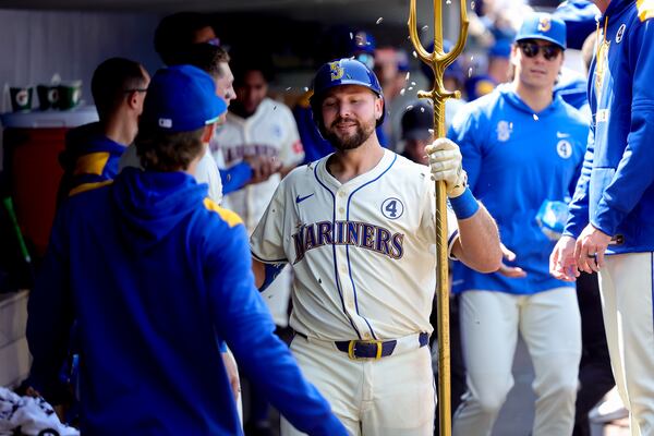 Seattle Mariners' Cal Raleigh, center, celebrates in the dugout after hitting a solo home run during the seventh inning of a baseball game against the Minnesota Twins, Sunday, Jun 1, 2025, in Seattle. (AP Photo/Ryan Sun)