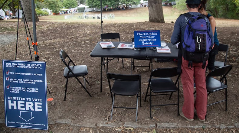 Greg Sawicki checks to make sure his voter registration is in order during the Candler Park Fall Fest 2019 in Atlanta. STEVE SCHAEFER / SPECIAL TO THE AJC