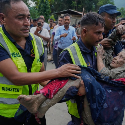 Rescuers carry a victim of flash flooding to safety along the Trishuli River in Nepal's Nuwakot district, Wednesday, Aug. 26, 2026. (AP Photo/Niranjan Shrestha)