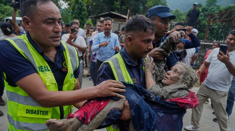Rescuers carry a victim of flash flooding to safety along the Trishuli River in Nepal's Nuwakot district, Wednesday, Aug. 26, 2026. (AP Photo/Niranjan Shrestha)