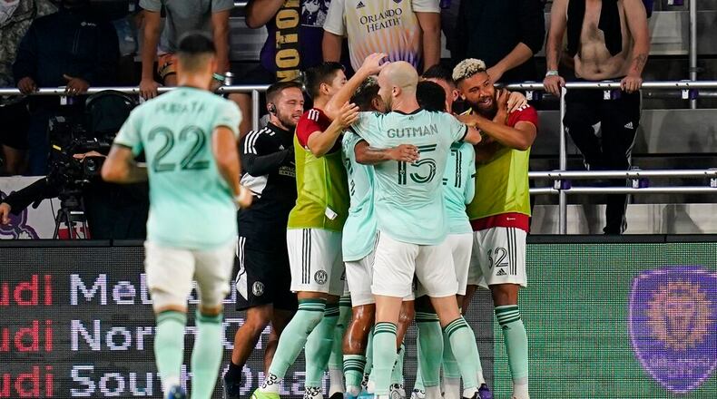 Atlanta United players celebrate as they surround midfielder Thiago Almada after he scored a goal against Orlando City during the second half of an MLS soccer match Wednesday, Sept. 14, 2022, in Orlando, Fla. (AP Photo/John Raoux)