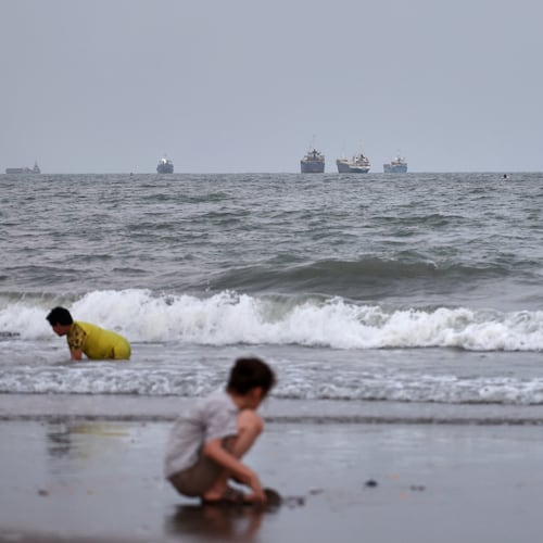 Children play at a beach as commercial vessels are anchored in the Strait of Hormuz off Bandar Abbas, Iran, Wednesday, Aug. 26, 2026. (Amir Biazar/ISNA via AP)