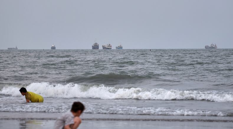 Children play at a beach as commercial vessels are anchored in the Strait of Hormuz off Bandar Abbas, Iran, Wednesday, Aug. 26, 2026. (Amir Biazar/ISNA via AP)