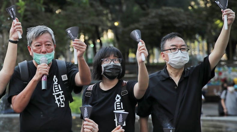 FILE - Fom left, pro-democracy activists Lee Cheuk-yan, Chow Hang-tung, and Cheung Man-kwong attend a gathering to mourn for those killed in the 1989 Tiananmen crackdown at Victoria Park, in Hong Kong on June 4, 2020. (AP Photo/Kin Cheung, File)
