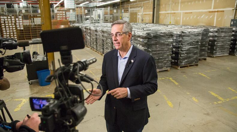 The Secretary of State Brad Raffensperger talks to the media in front of old voting machines while waiting for the largest shipment of Georgia’s new secure paper-ballot voting machines at the Dekalb County Voter Registration & Elections offices in Avondale Estates on Monday December 30th, 2019. 2839 units are to be delivered for Dekalb County. (Photo by Phil Skinner).
