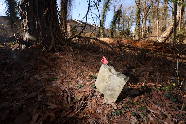 Gravestones are overgrown at the historic Piney Grove Cemetery next to the Bluffs at Lenox townhome community in Buckhead. (Jason Getz/AJC)