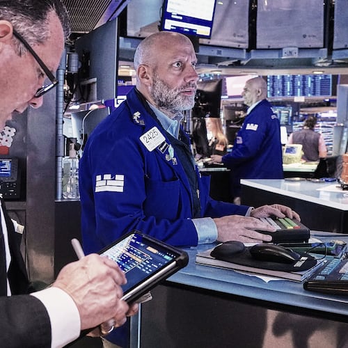 Trader Edward Curran, left, and specialist Meric Greenbaum, center, work on the floor of the New York Stock Exchange, Friday, May 22, 2026. (AP Photo/Richard Drew)