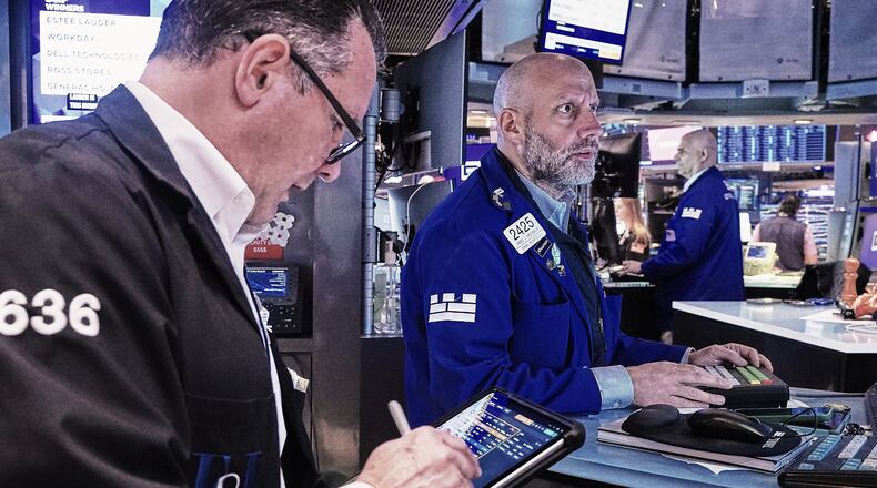 Trader Edward Curran, left, and specialist Meric Greenbaum, center, work on the floor of the New York Stock Exchange, Friday, May 22, 2026. (AP Photo/Richard Drew)
