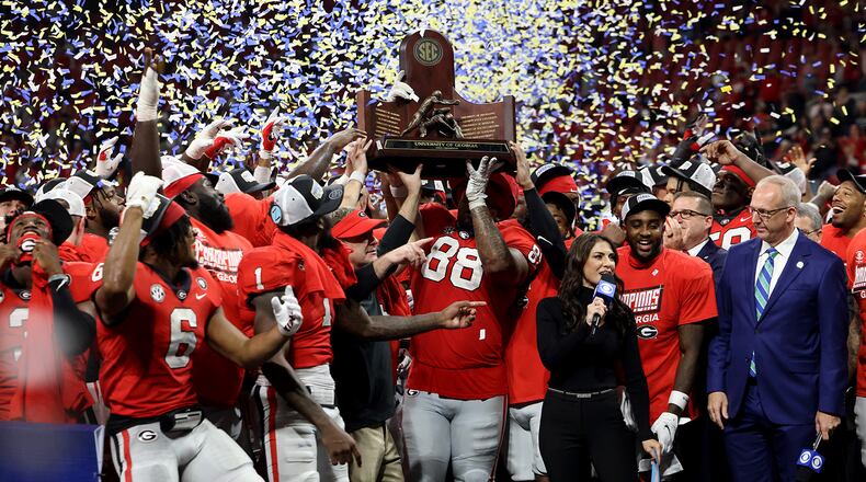 Georgia Bulldogs players hold up the SEC Championship trophy after their 50-30 win against the LSU Tigers during the SEC Championship game at Mercedes-Benz Stadium, Saturday, Dec. 3, 2022, in Atlanta. (Jason Getz/Atlanta Journal-Constitution/TNS)