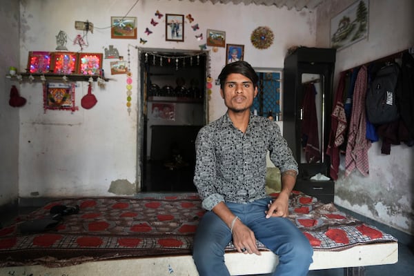 Veer Vanzara sits inside his house with reflective paint on the roof that helps keep the indoors cooler in Ahmedabad, India, Wednesday, April 2, 2025. (AP Photo/Ajit Solanki)