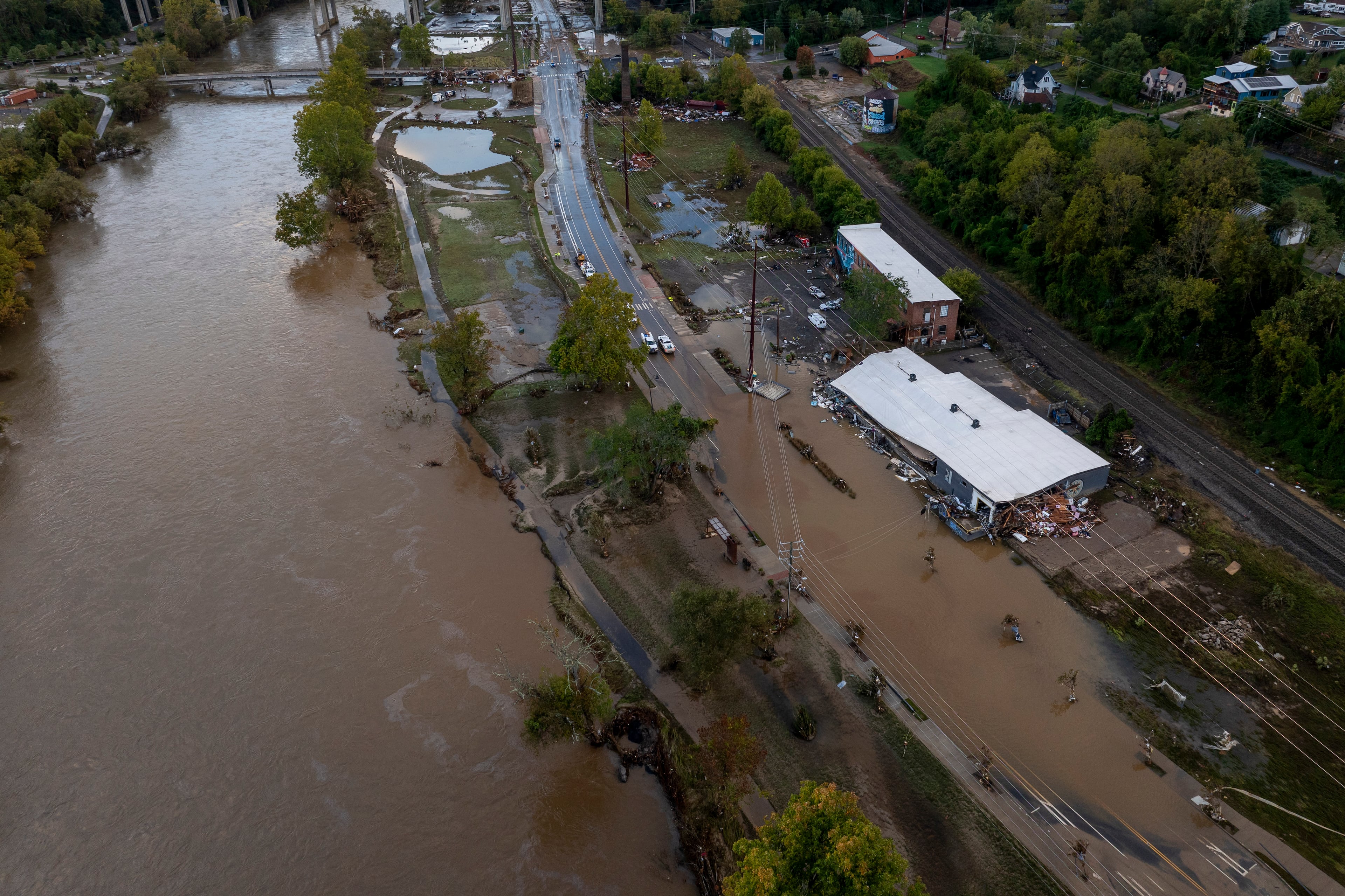 Floodwaters and debris flow along the French Broad River in the River Arts District in Asheville, North Carolina more than two weeks after Hurricane Helene hit. (Loren Elliott/The New York Times 2024)