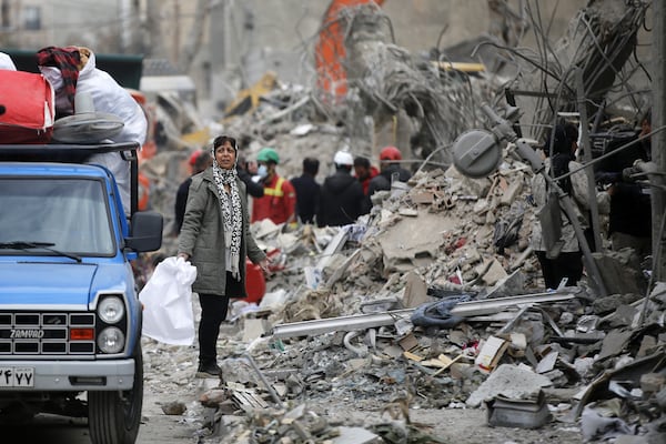 A woman walks among the rubble near Risalat Square after Israeli and US strikes caused heavy destruction in eastern Tehran on March 12, 2026. At least 40 people were reported killed in the attacks. (Fatemeh Bahrami/Anadolu via Getty Images)