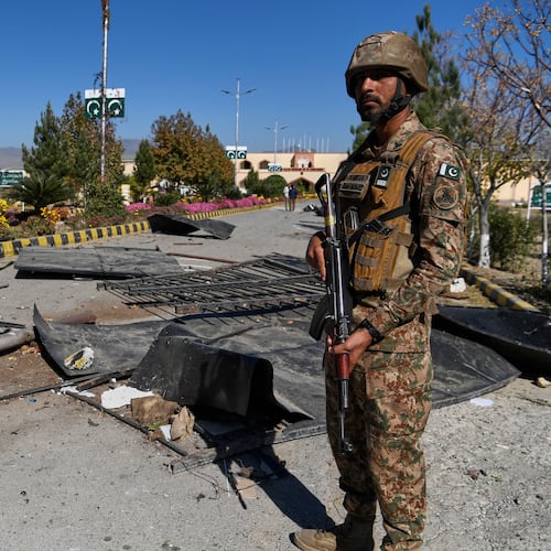 An Army soldier stands guard next to damages at the main gate of an army-run cadet college that was assaulted by militants on Monday, in Wana, a city in the northwestern Pakistani district South Waziristan bordering with Afghanistan, Thursday, Nov. 13, 2025. (AP Photo/Ahsan Shahzad)