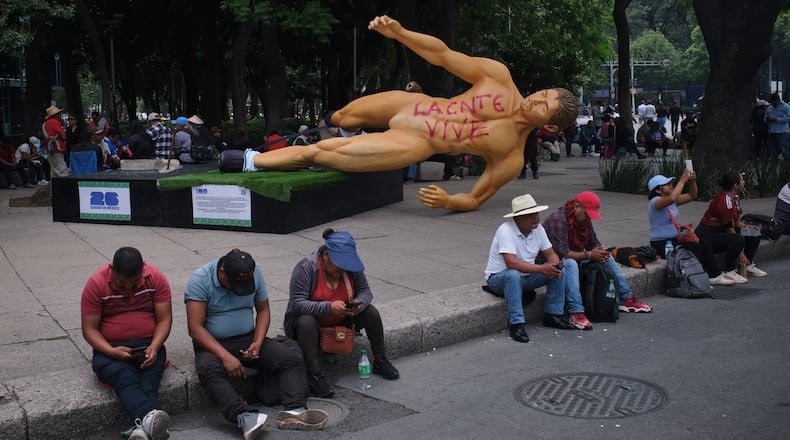 A World Cup statue, with graffiti that reads in Spanish, "The National Educational Workers Coordination lives" lies sideways during a teachers' protest for higher salaries sit in Mexico City, Tuesday, June 2, 2026. (AP Photo/Jon Orbach)