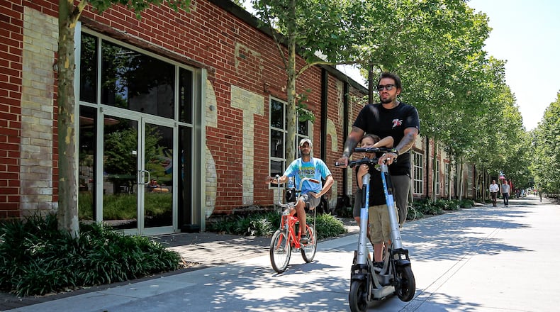 People in scooter and bike ride across a trail by Krog Street Market in Atlanta, Georgia on Thursday, June 13, 2024. (Ziyu Julian Zhu / AJC)