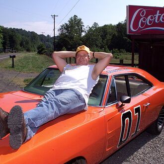 Ben Jones sits atop the General Lee, an orange 1969 Dodge Charger, outside "Cooter's," his roadside store in Sperryville, Va. Jones, who served from 1989 to 1993 as a Democratic congressman from Georgia, returned to his "Dukes of Hazzard" roots after his time in office, living his role as Cooter, the show's greasy, good-natured mechanic. From Thursdays through Sundays, Jones presided at a garage converted to the "Hazzard General Store" beside a two-lane highway winding toward Shenandoah National Park. (Rick McKay/Cox Washington Bureau 1999)