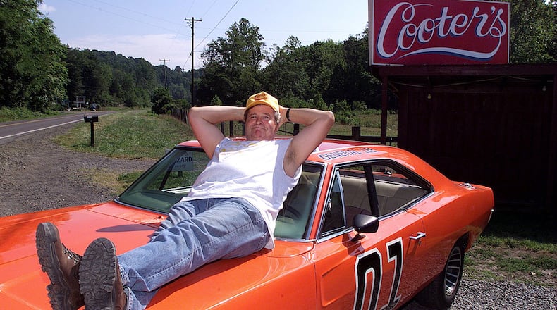 Ben Jones sits atop the General Lee, an orange 1969 Dodge Charger, outside "Cooter's," his roadside store in Sperryville, Va. Jones, who served from 1989 to 1993 as a Democratic congressman from Georgia, returned to his "Dukes of Hazzard" roots after his time in office, living his role as Cooter, the show's greasy, good-natured mechanic. From Thursdays through Sundays, Jones presided at a garage converted to the "Hazzard General Store" beside a two-lane highway winding toward Shenandoah National Park. (Rick McKay/Cox Washington Bureau 1999)