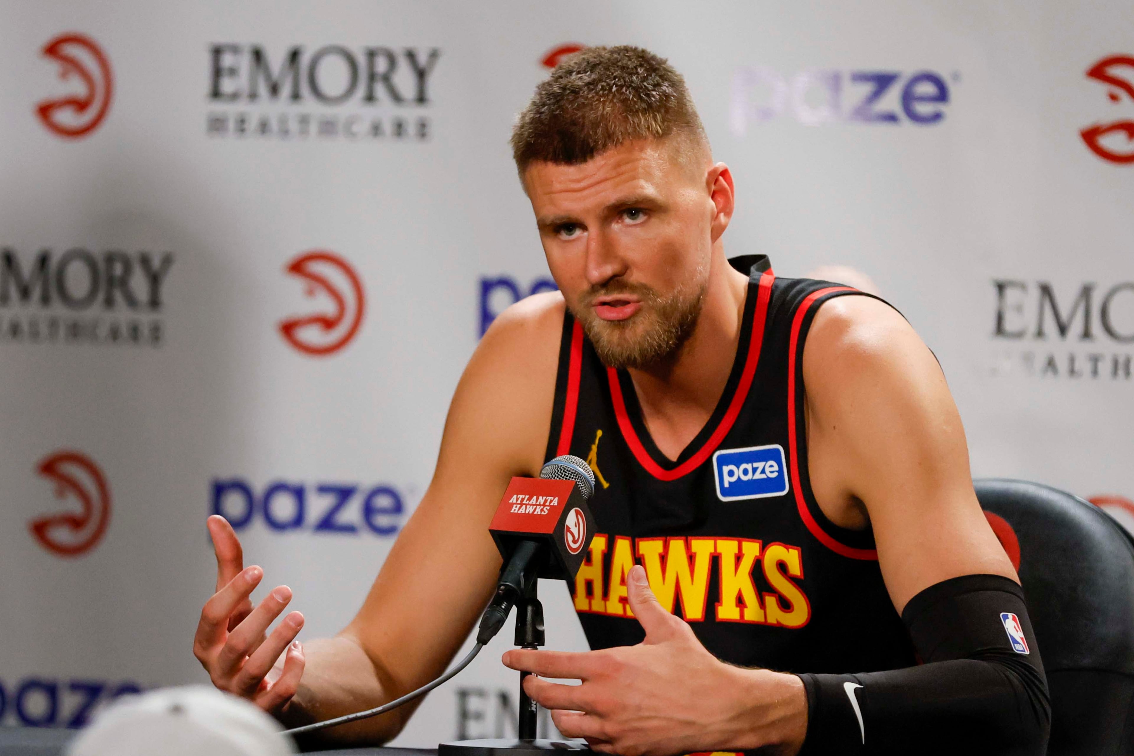 Hawks center Kristaps Porzingis answers a question at media day.